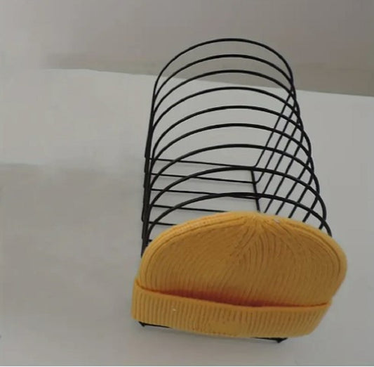 Freestanding Iron Organizer metal wire rack holding books and colorful winter caps on a table in Pakistan