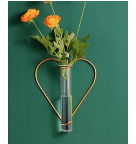 Modern hexagon gold metal wall vase with glass tube and orange flowers for minimalist interior.