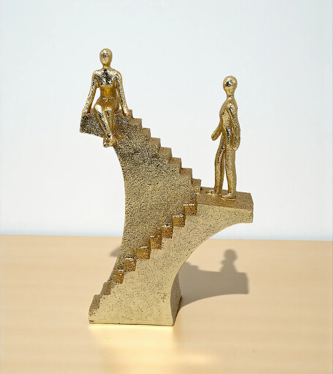 imported statue climbing stair and sit on stairs golden 9.6x6.5 Price in Pakistan placed over a drawing room centerpiece table