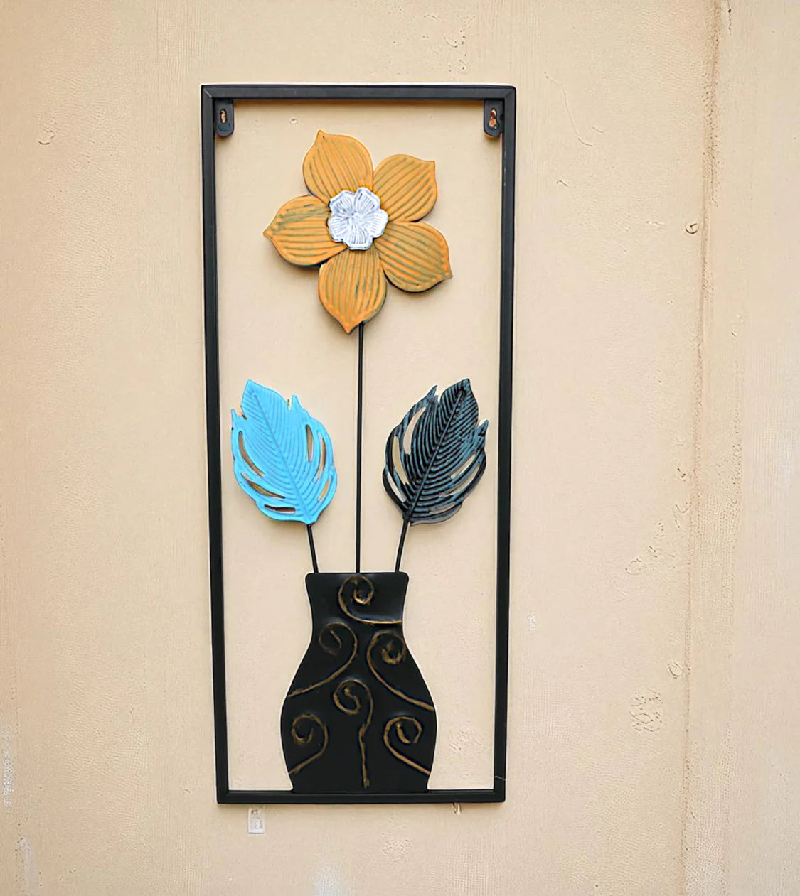 Metal Wall Hanging Floral Rectangle Black with 3D metal monstera leaf wall sculpture displayed on a lounge wall in Pakistan