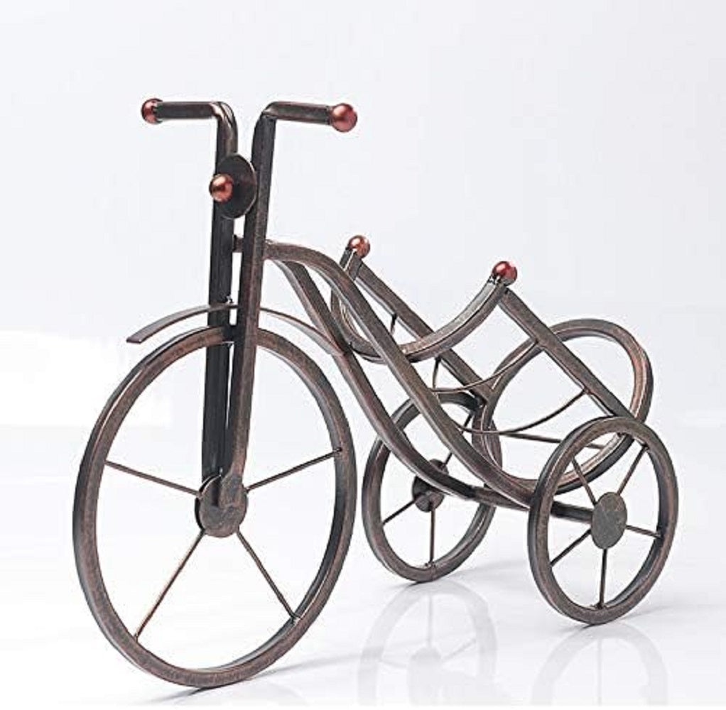 Bronze Metal Artistic Bicycle Drink Holder Stand cradling a cold drink bottle on a white dining table in Pakistan