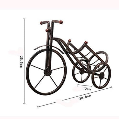 Bronze Metal Artistic Bicycle Drink Holder Stand cradling a cold drink bottle on a white dining table in Pakistan