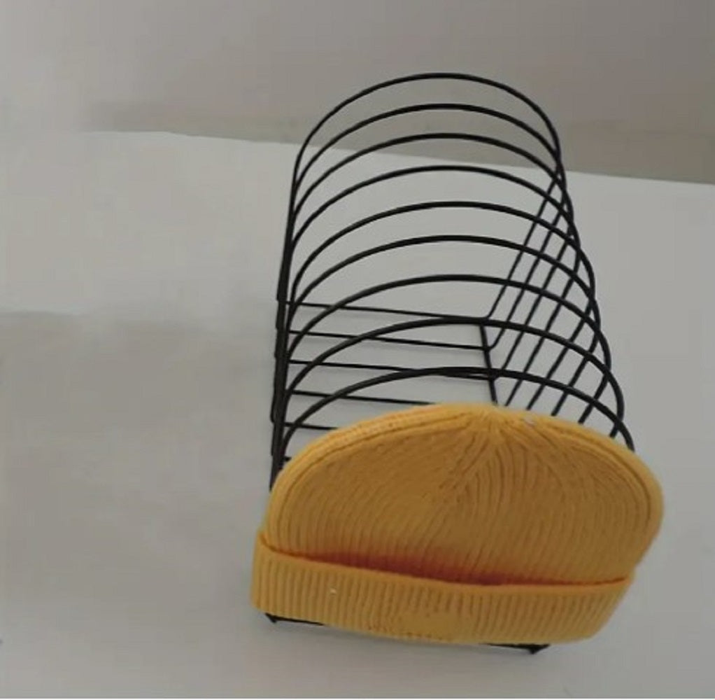 Freestanding Iron Organizer metal wire rack holding books and colorful winter caps on a table in Pakistan