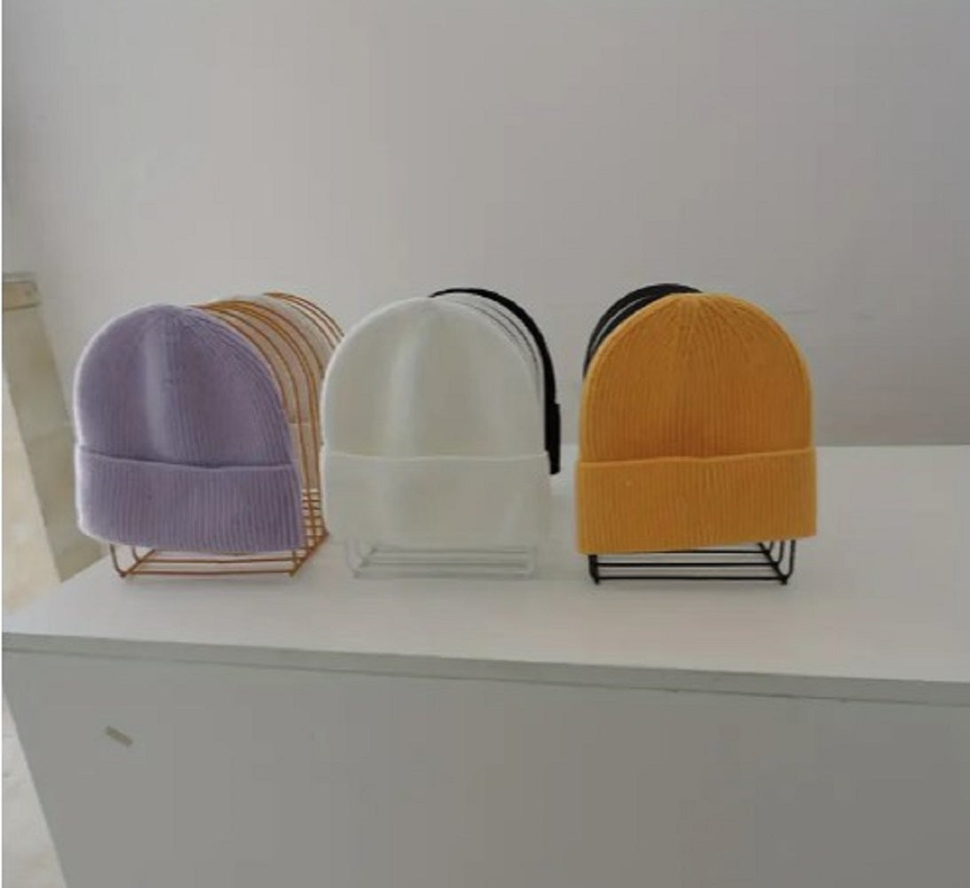 Freestanding Iron Organizer metal wire rack holding books and colorful winter caps on a table in Pakistan