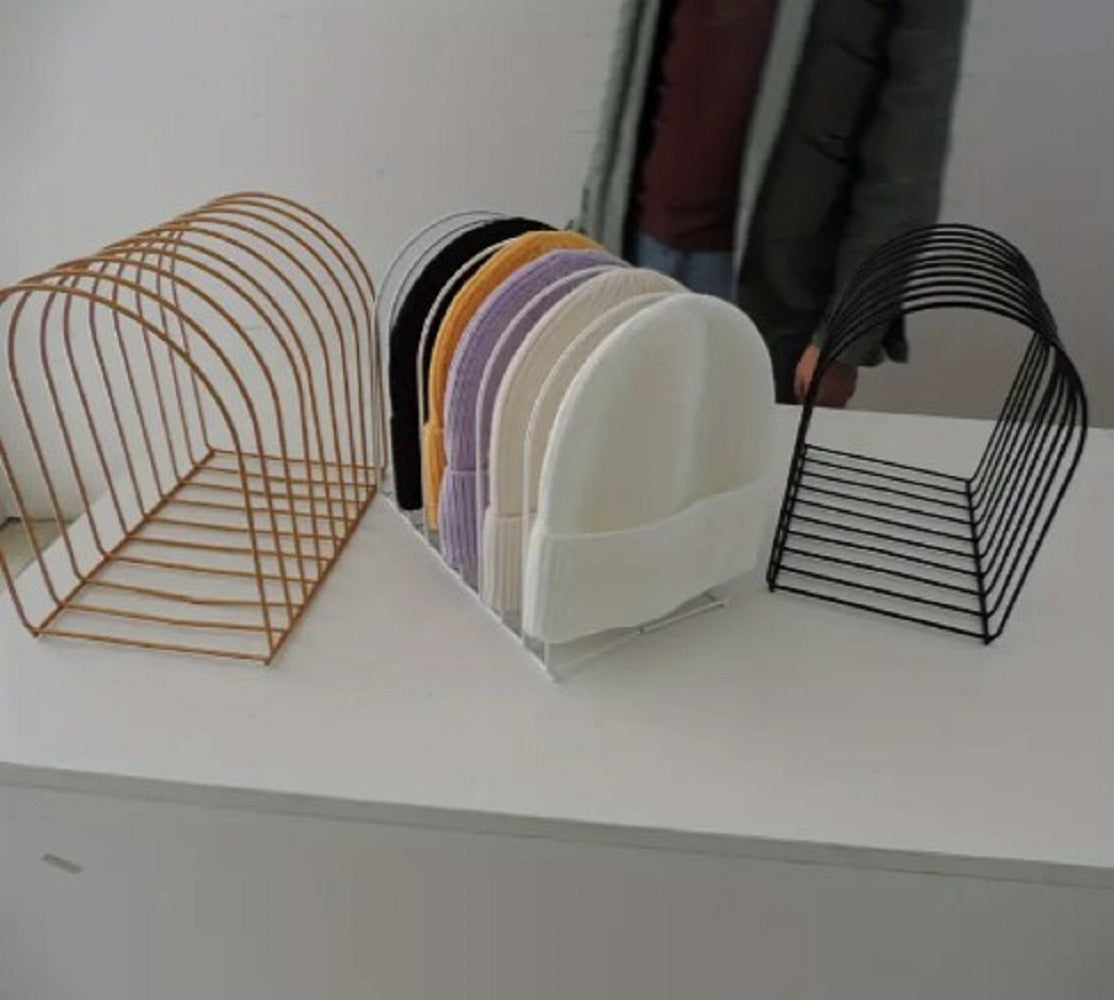 Freestanding Iron Organizer metal wire rack holding books and colorful winter caps on a table in Pakistan
