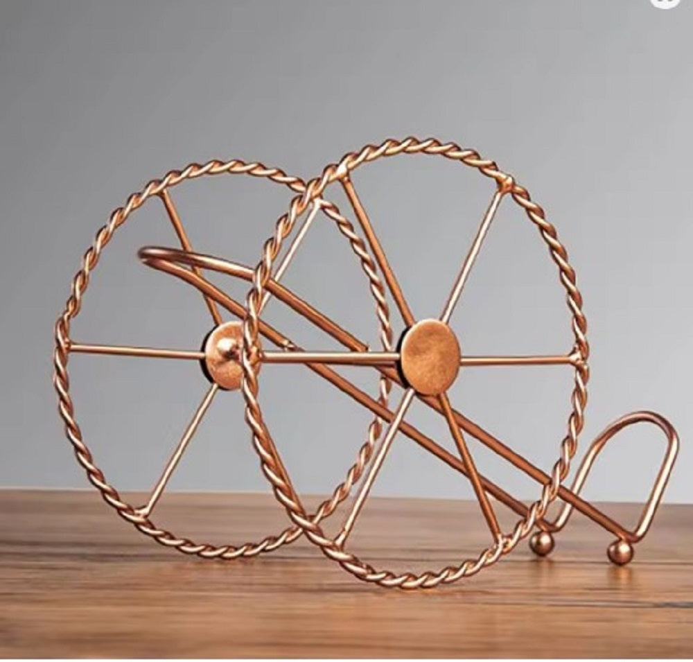 Copper decorative wheel on a wooden surface with a gray background