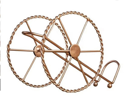 Decorative metal wall piece with a wheel design on a white background