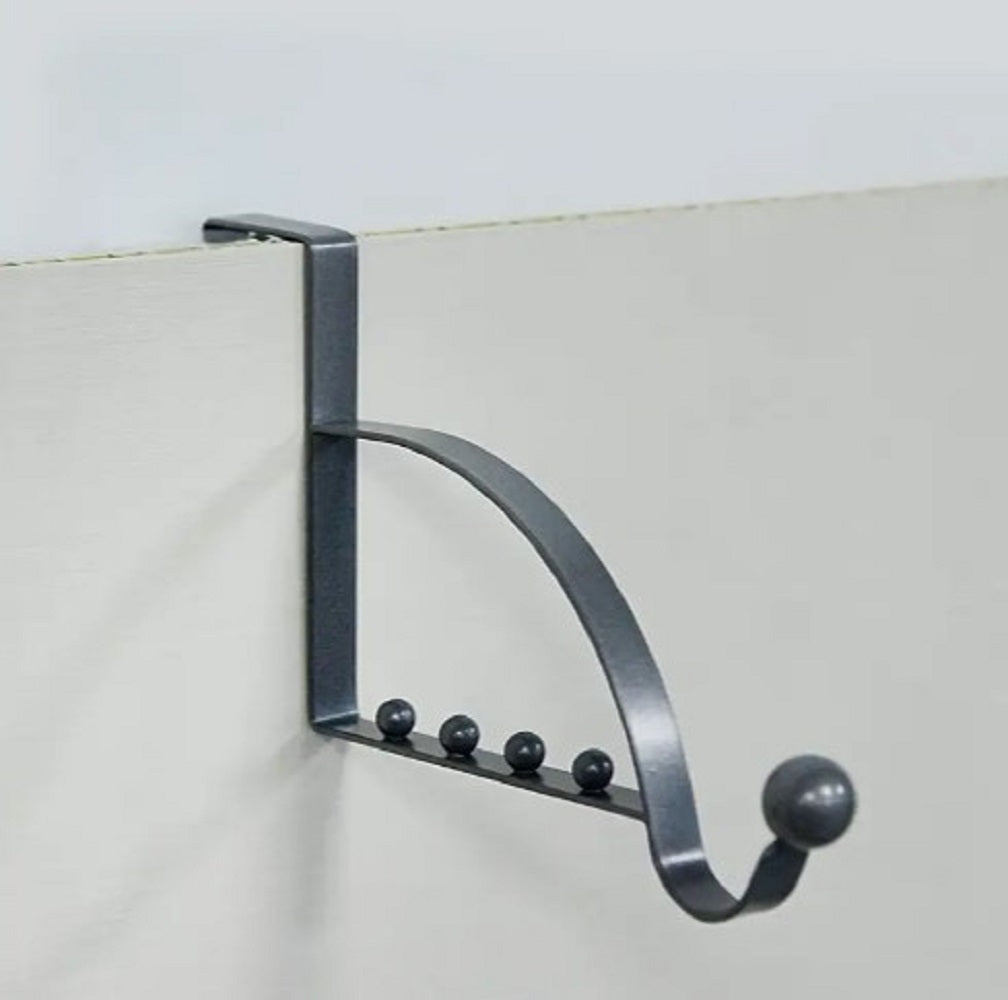 Black metal Over-the-Door Coat Rack with non-slip hooks hanging jackets and bags behind a bedroom door in Pakistan