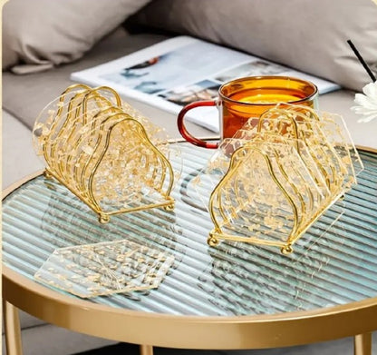 Luxury Gold Metal Plate Coaster Stand holding acrylic gold-flake coasters on a glass dining table in Pakistan