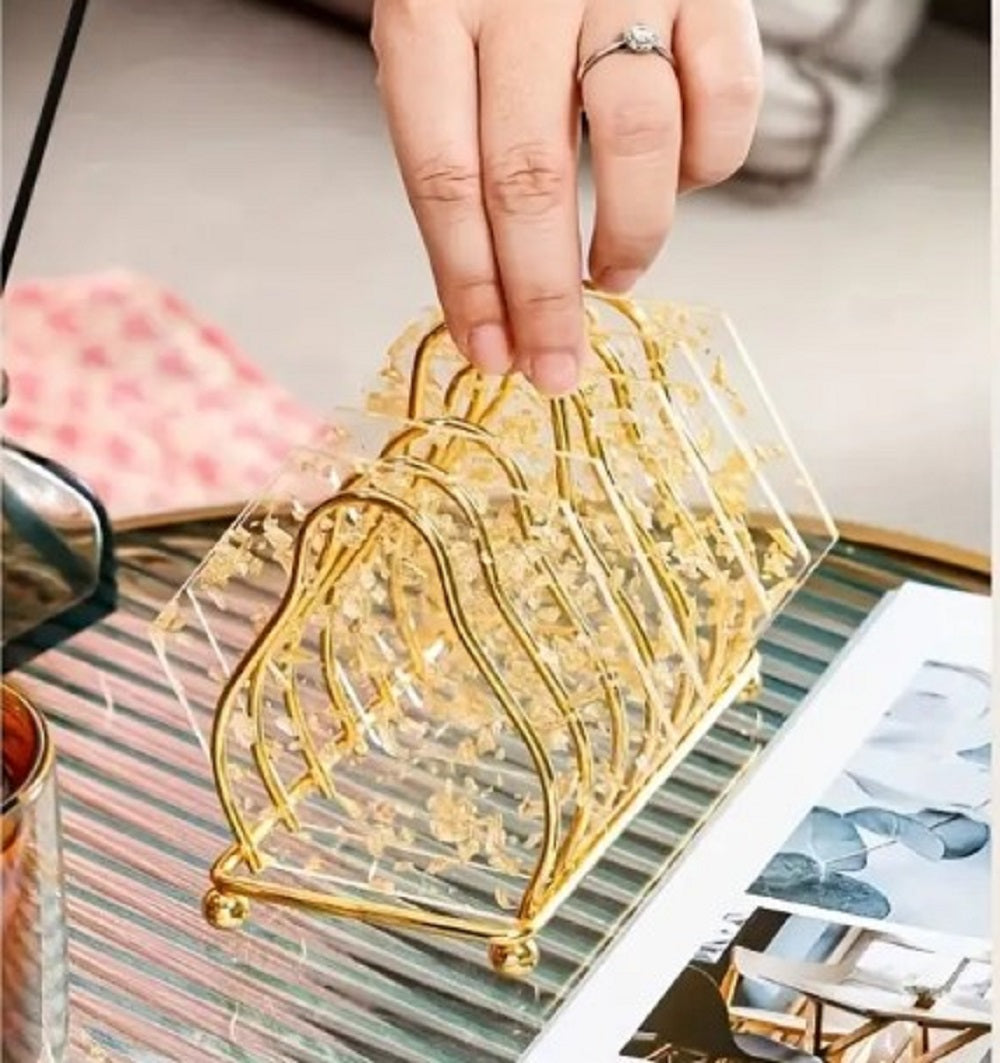 Luxury Gold Metal Plate Coaster Stand holding acrylic gold-flake coasters on a glass dining table in Pakistan