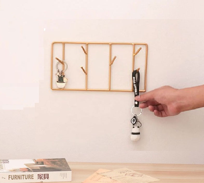 Minimalist gold metal wall key holder with five hooks and hanging keys - Modern entryway organization Pakistan.