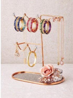Elegant metal jewelry organizer stand displaying earrings and necklaces on a vanity table for easy access and stylish storage.