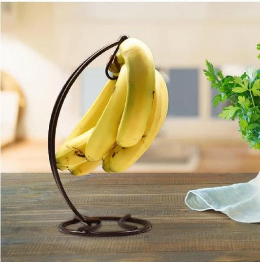 Banana hanger stand, black metal fruit holder, kitchen counter organizer, banana tree stand, modern kitchen accessories, minimalist banana hook, fruit display stand, space saving kitchen decor, black iron banana hanger, durable fruit stand, countertop organizer, fresh fruit storage, banana holder rack, kitchen organization, stylish fruit hook, rust resistant banana stand, kitchen gadget, banana display, tabletop fruit holder, home decor kitchen.