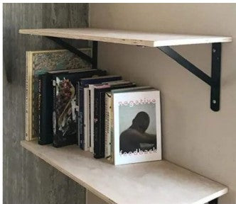 Wall-mounted wooden shelf supported by strong metal L-brackets with books and decor items
