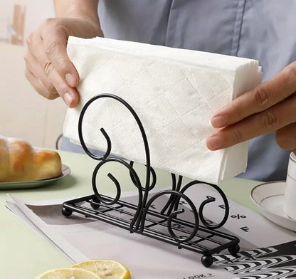 Black tissue stand, vertical napkin holder, metal tissue rack, wrought iron scroll holder, elegant dining table accessories, minimalist kitchen counter organizer, restaurant tabletop napkin server, matte black tissue dispenser, wedding catering buffet display, modern room tissue organizer, upright paper napkin frame, wire frame napkin cradle, dinner party tissue stand, boutique hotel tableware utilities, fancy tissue paper rack, black iron napkin basket, decorative table storage tray, home buffet server acc