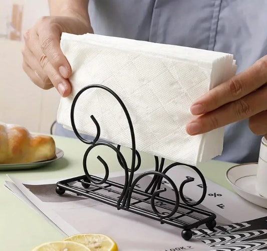 Black tissue stand, vertical napkin holder, metal tissue rack, wrought iron scroll holder, elegant dining table accessories, minimalist kitchen counter organizer, restaurant tabletop napkin server, matte black tissue dispenser, wedding catering buffet display, modern room tissue organizer, upright paper napkin frame, wire frame napkin cradle, dinner party tissue stand, boutique hotel tableware utilities, fancy tissue paper rack, black iron napkin basket, decorative table storage tray, home buffet server acc